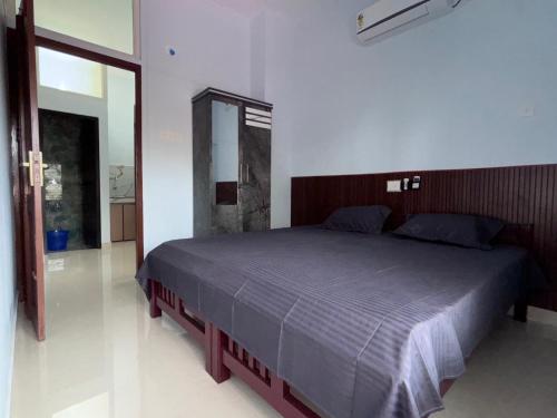 a bedroom with a bed in a white room at DEN LODGE in Kulasegaram