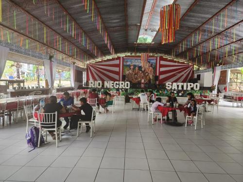 a group of people sitting at tables in a restaurant at El Encanto de Las Marias in Satipo