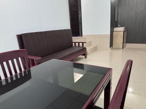 a living room with a couch and a table and chairs at DEN LODGE in Kulasegaram