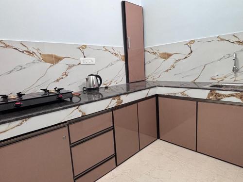 a kitchen with brown and white marble counter tops at DEN LODGE in Kulasegaram
