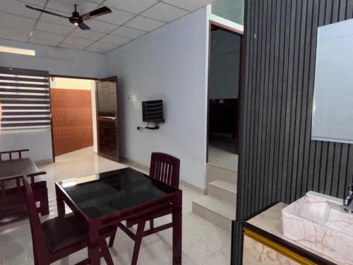 a dining room with a table and chairs in a room at DEN LODGE in Kulasegaram