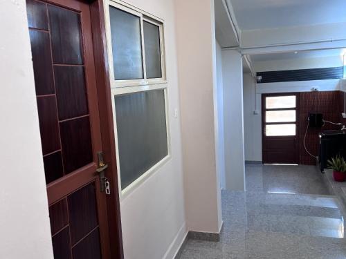 an empty hallway with a door and a hallway with a hallway at DEN LODGE in Kulasegaram