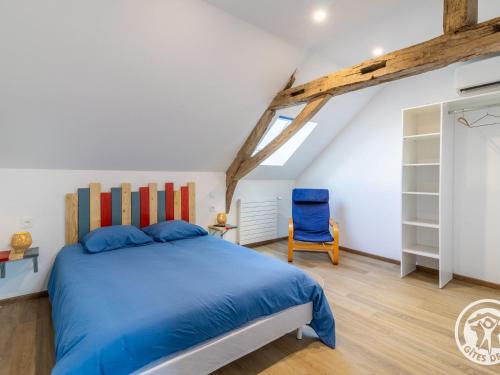una camera da letto con un letto e una sedia blu di Grande maison à la campagne avec piscine et climatisation - FR-1-622-113 a Chazé-sur-Argos
