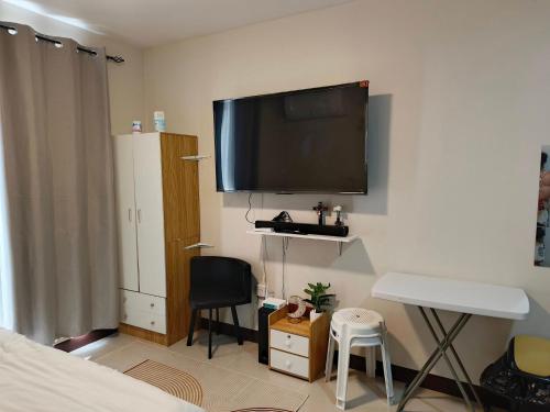 a bedroom with a flat screen tv on the wall at JJL Suites for DAILY RENTAL in Suba