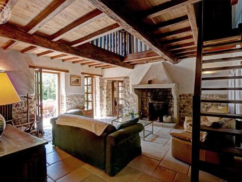 Una sala de estar con un sofá y una chimenea. en Domaine de Campagne : Charme Authentique avec Piscine et Spa - FR-1-496-364, en Essertines-en-Donzy