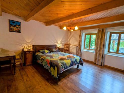 ein Schlafzimmer mit einem Bett und einer Holzdecke in der Unterkunft Maison spacieuse avec spa, ping-pong et baby-foot, idéale pour détente en famille - FR-1-589-828 in La Chapelle-aux-Bois