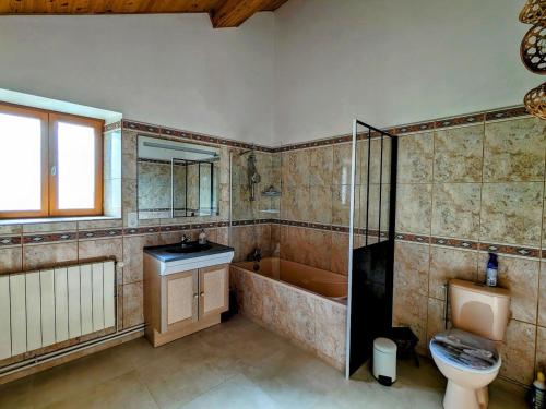 ein Badezimmer mit Badewanne, Toilette und Waschbecken in der Unterkunft Maison spacieuse avec spa, ping-pong et baby-foot, idéale pour détente en famille - FR-1-589-828 in La Chapelle-aux-Bois