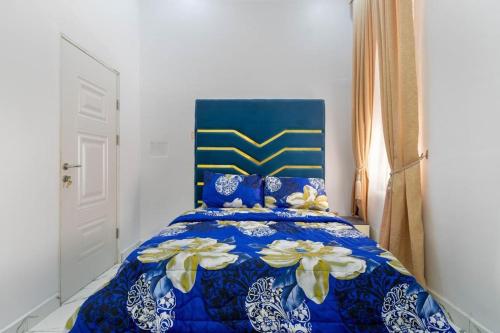 Una cama azul con flores en una habitación en Excel 4bedroom orchid lekki Lagos, en Mama