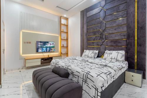 Un dormitorio con una cama y un televisor de pantalla plana. en Excel 4bedroom orchid lekki Lagos, en Mama