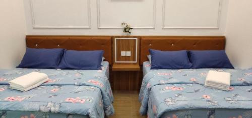 a bedroom with two beds with blue pillows at Captain's Cabin Resort - Naval Heritage (Swimming Pool) in Kota Bharu