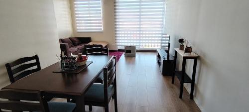 a living room with a table and chairs and a couch at Departamento en condominio privado Puerto Montt in Puerto Montt