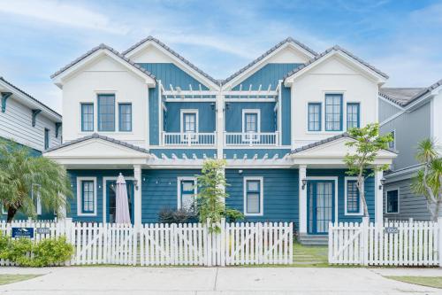 a blue and white house with a white picket fence at DT Retreat - Biệt thự nguyên căn - 3 Phòng ngủ - Novaworld Phan Thiết in Phan Thiet