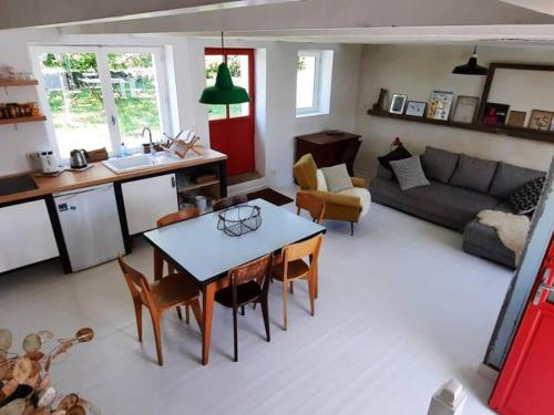 a kitchen and living room with a table and chairs at Maison charmante au calme avec jardin à Kerlard - FR-1-813-24 in Groix