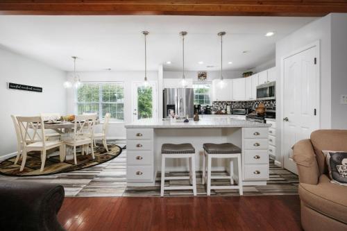 a kitchen with a white island and a table at Sweet Pea Cottage Updated furnishings arcade game HOA Community Outdoor Pool in Pigeon Forge