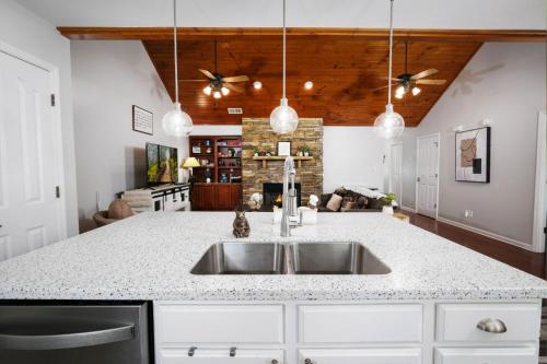 a kitchen with a sink and a living room at Sweet Pea Cottage Updated furnishings arcade game HOA Community Outdoor Pool in Pigeon Forge