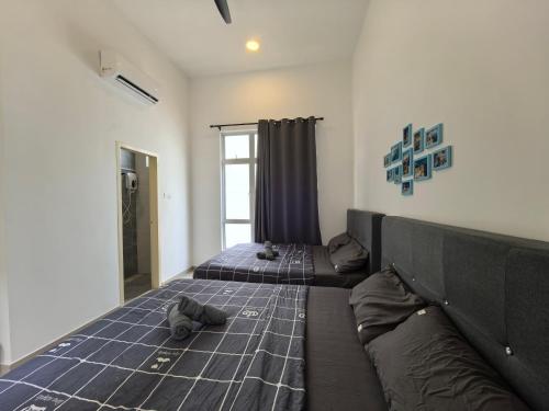 a bedroom with two beds and a couch at Padang Serai Wangi Roomstay 91 in Padang Serai