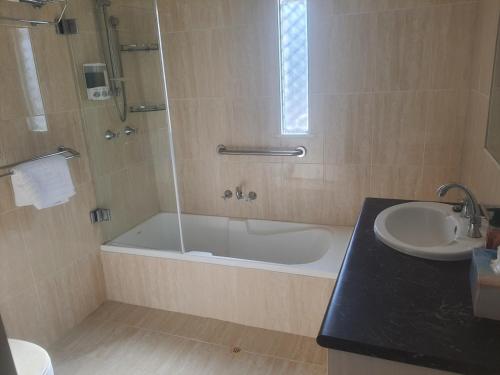 a bathroom with a shower and a tub and a sink at Norseman Heart of the Western Woodlands in Norseman