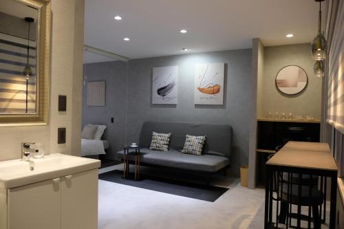 - un salon avec un canapé et un lavabo dans l'établissement Jasmin錦町 4F, à Takamatsu