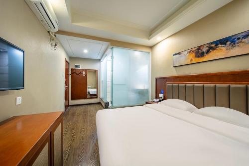 Una cama o camas en una habitación de Harbin Huaxi Hotel - Ice World Branch