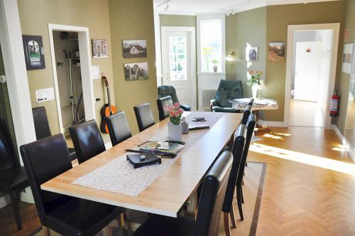 a dining room with a long wooden table and chairs at Villa Ekebo Bed & Kitchen in Borgholm