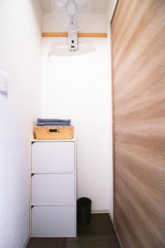 a room with a white cabinet and a door at Kominka Wagaya in Higashi-osaka