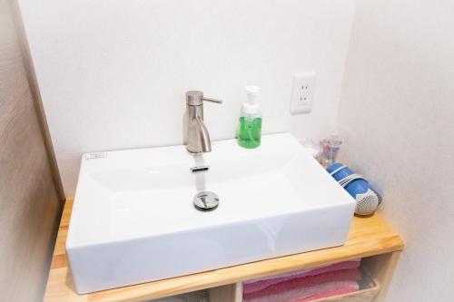 a white bathroom sink sitting on top of a table at Kominka Wagaya in Higashi-osaka