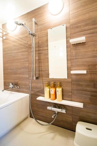 a bathroom with a shower and a toilet and a sink at Kominka Wagaya in Higashi-osaka