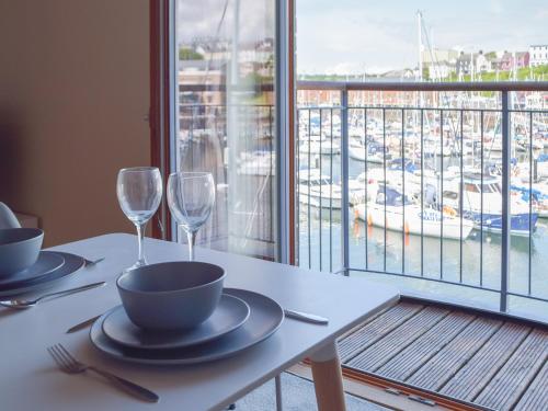 a table with two wine glasses and a view of a harbor at Marina Retreat in Milford Haven