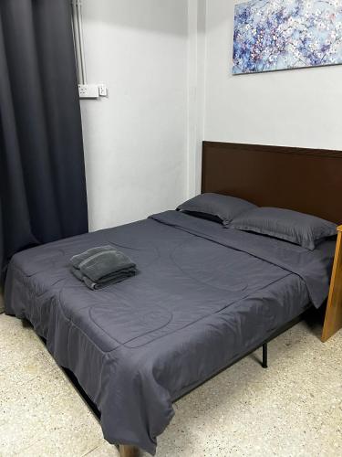 a bed with a blue comforter in a bedroom at MDF Payang Guesthouse in Kuala Terengganu