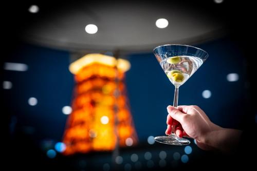 a person holding a martini glass with a drink at The Prince Park Tower Tokyo - Preferred Hotels & Resorts, LVX Collection in Tokyo