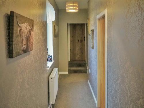 a hallway with a stairway with a horse painting on the wall at Valhalla Brae in Keiss