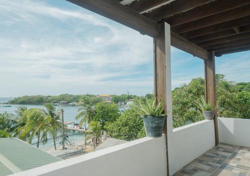 a balcony with potted plants and a view of the water at West end inn in West End
