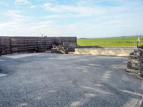 a bridge over a road with a field in the background at Valhalla Brae in Keiss