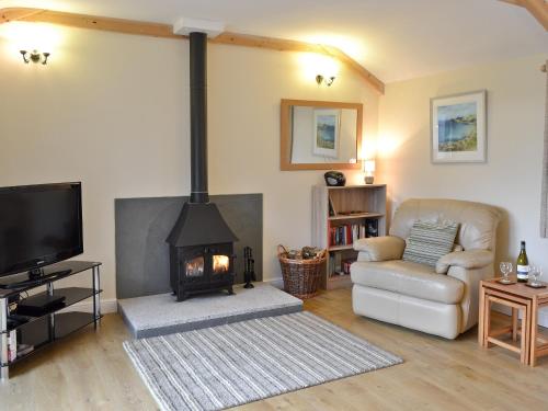 a living room with a fireplace and a couch at Tresidder Barn in Constantine
