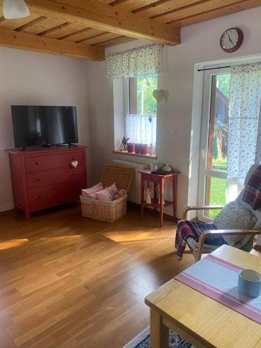 a living room with a tv and a wooden floor at Chalúpka u MAŤA in Terchová