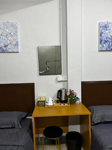 a room with a table with a coffee pot on it at MDF Payang Guesthouse in Kuala Terengganu