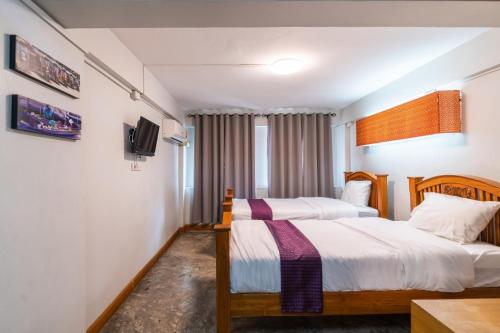 a hotel room with two beds and a tv at XX GO INN Khaosan - โกอินน์ ถนนข้าวสาร in Bangkok