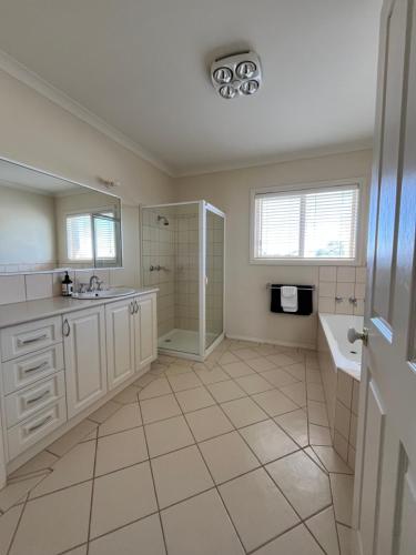 a white bathroom with a sink and a shower at Lake Boga Waterfront in Lake Boga