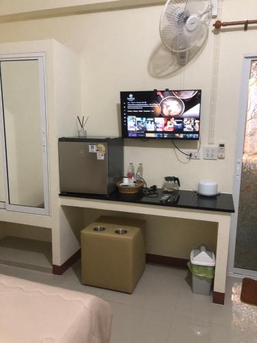a room with a desk with a television and a fan at Boontorsub in Ban Khlong Samrong