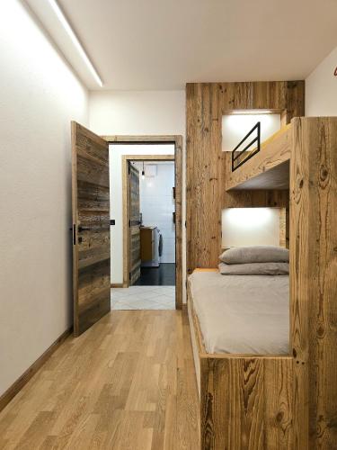 a bedroom with a bunk bed and wooden walls at Dolomiten Lounge - moderno con parcheggio privato in Pergine Valsugana