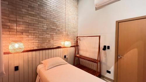 a bedroom with a bed and a brick wall at Chalés Arco-Íris in Ribeirão Claro