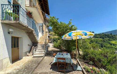 a table with an umbrella next to a building at Beautiful Home In Sovramonte With Wifi in Sovramonte