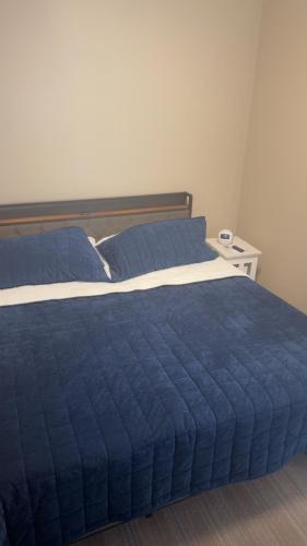 a bed with a blue comforter in a bedroom at Willow e-hotel in Mattoon