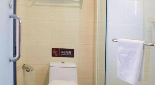 a bathroom with a toilet and a sign on the wall at 7 Days Premium Beijing Dabaotai Metro Station Luhua Road in Beijing