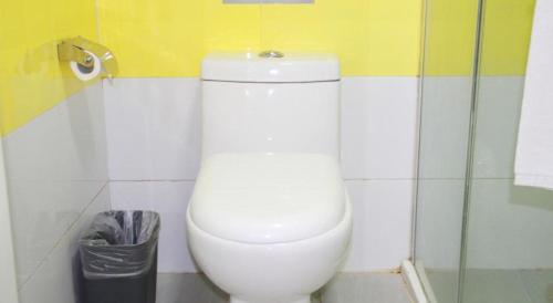 a white toilet in a bathroom with a trash can at 7 Days Premium Beijing Dabaotai Metro Station Luhua Road in Beijing