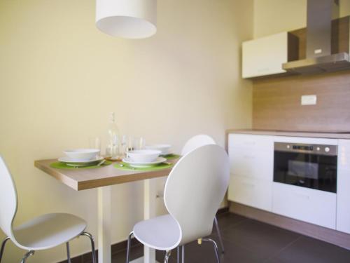 a kitchen with white chairs and a table and a microwave at Villa Irene in Trenčianske Teplice