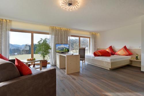 a large living room with a bed and a couch at Bauernhof Lindenhof in Scheffau am Wilden Kaiser