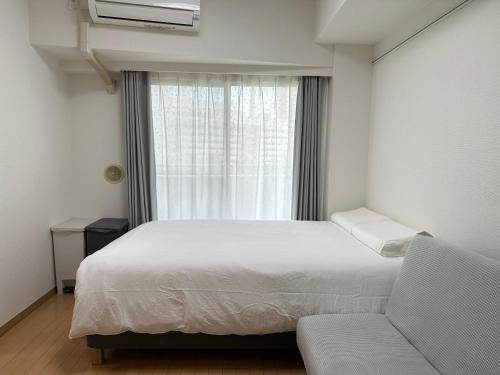a bedroom with a bed and a window and a couch at Sunshine Grand Hotel Ikebukuro in Tokyo