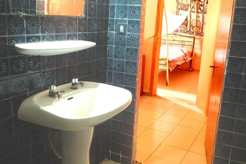 La salle de bains est pourvue d'un lavabo et d'un miroir. dans l'établissement Hotel de la Liberte, à Ouagadougou