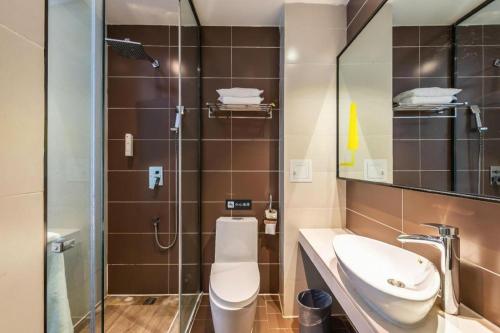 a bathroom with a toilet and a sink and a shower at IU Hotel Kunming Jinma Bijifang Joy City in Kunming